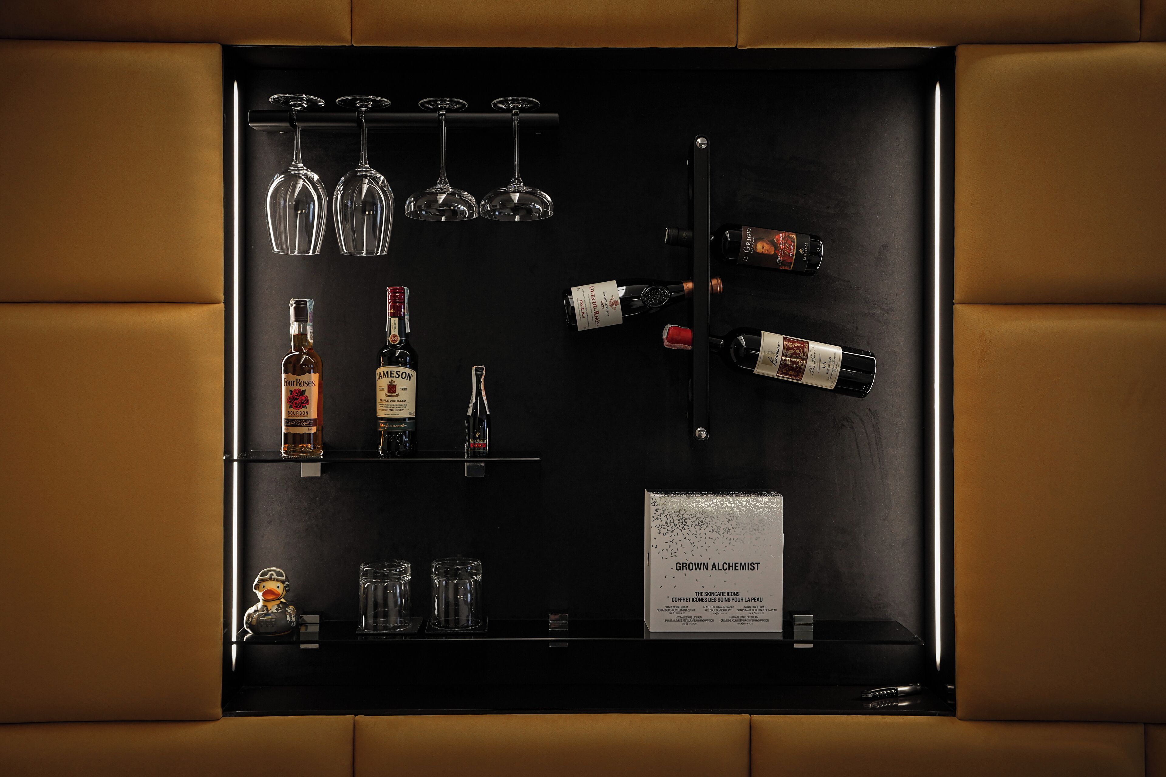 A black display case with wine glasses, bottles, and a menu titled "GROWN ALCHEMIST".