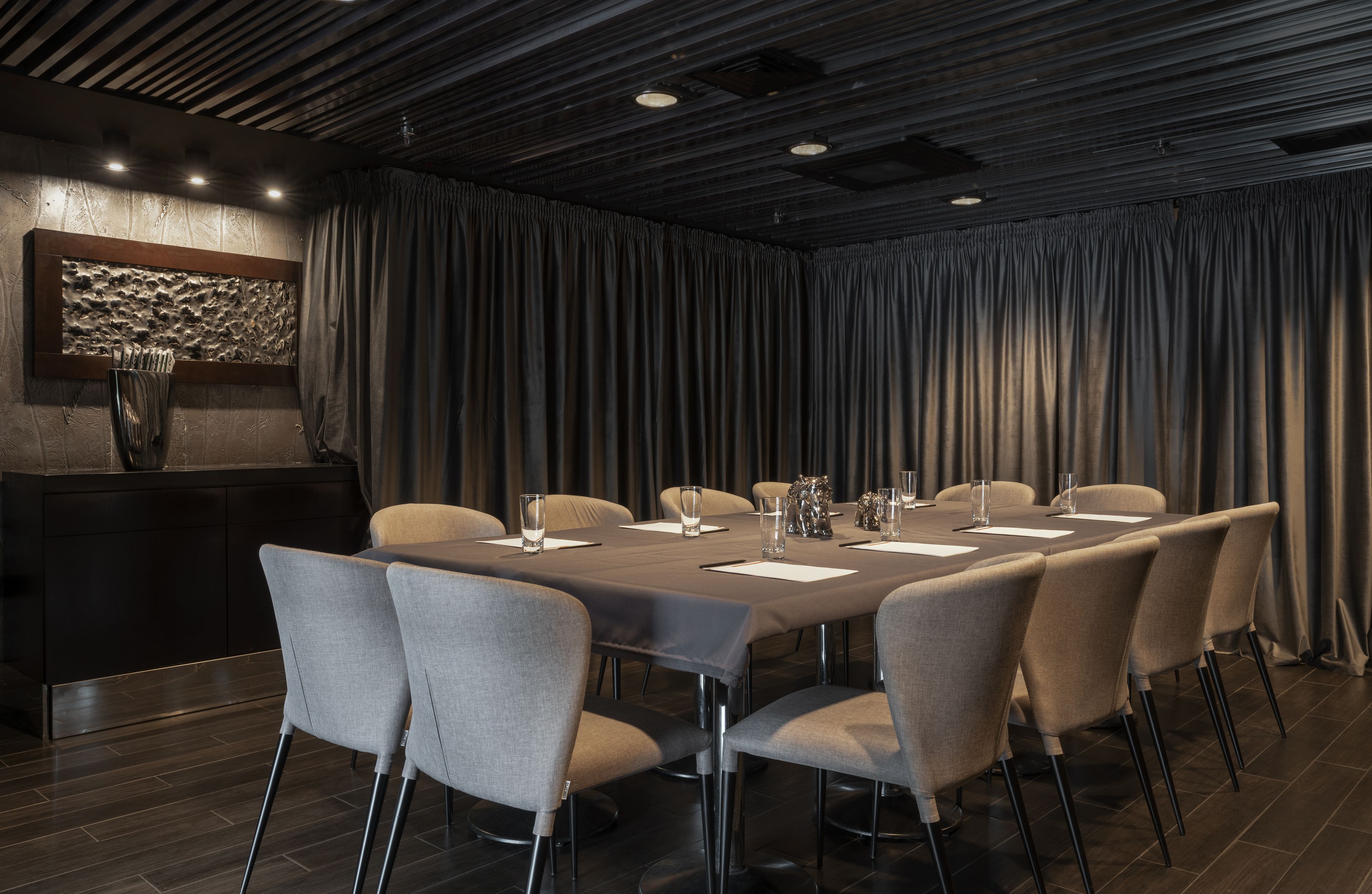 A conference room with a long table, eight chairs, and a podium.