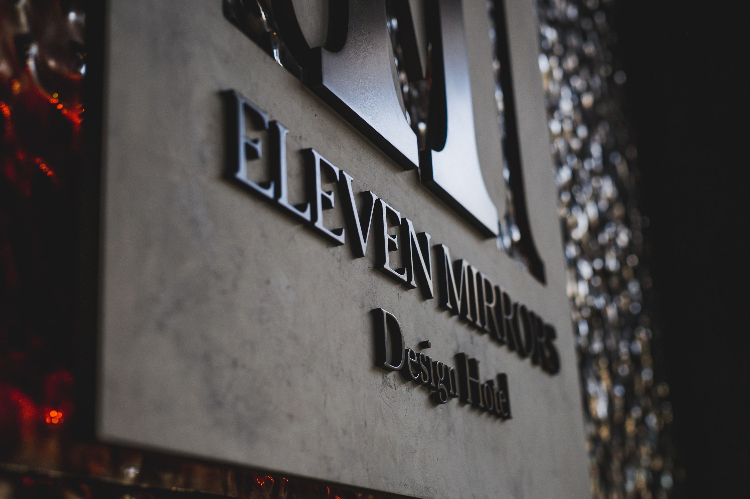Et skilt med navnet "ELEVEN MURRORS Design Hotel".