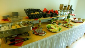 Una mesa de buffet con diversos alimentos y utensilios para servir.