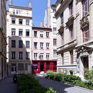 A narrow street lined with multi-story buildings, some with balconies and shutters. - Hotel Saint Vincent (Lyon)