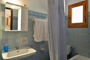 A bathroom with a sink, mirror, towel rack, shower curtain, and a window. - Feeloxenia Corfu Apartments (Corfu)