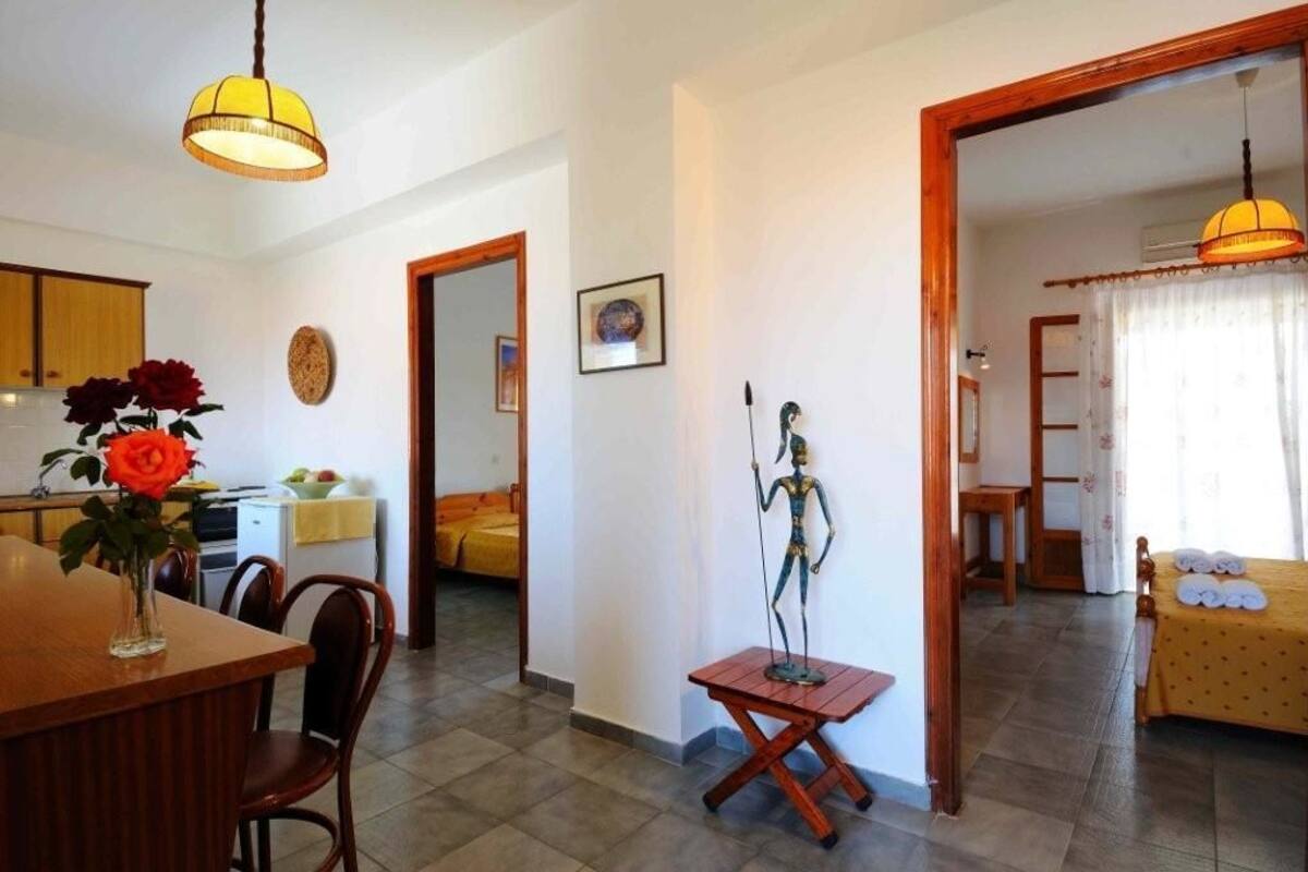 Un espacio habitable compacto con comedor, una pequeña cocina y un dormitorio.
