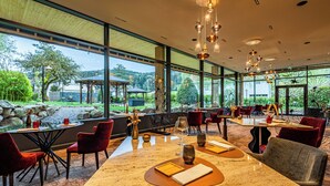 Un restaurant doté d’une terrasse, de grandes fenêtres et offrant une vue sur le paysage environnant.