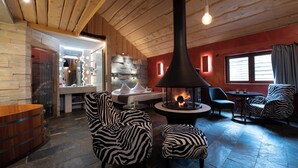 Un salon chaleureux avec une cheminée, un plafond en bois et des meubles à motifs zébrés.