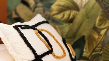A pillow with a black and gold design on a bed.