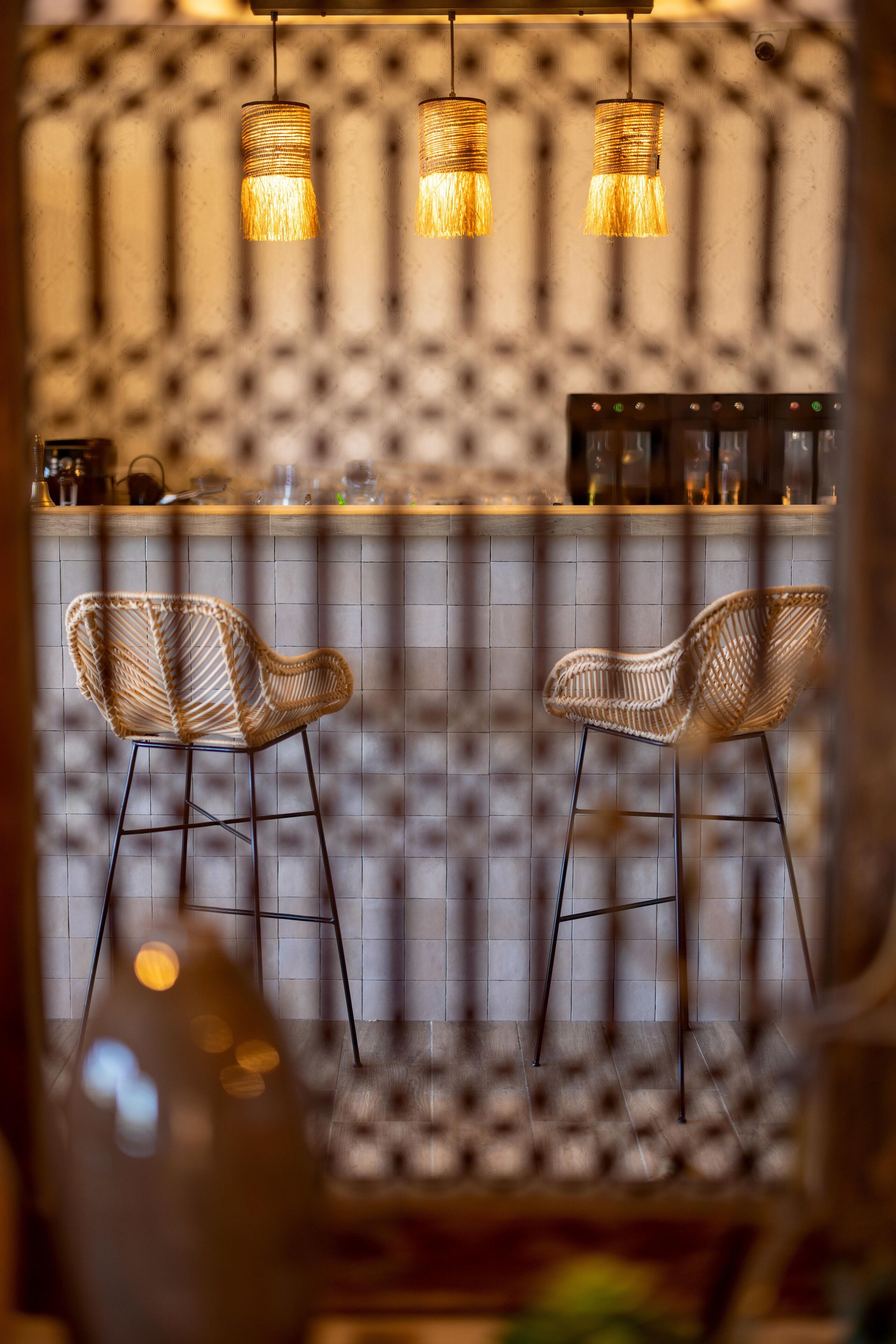 Een bar met rieten stoelen en hangende吊灯