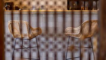 Een bar met rieten stoelen en hangende吊灯