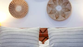 A bed with two pillows and two wall decorations.
