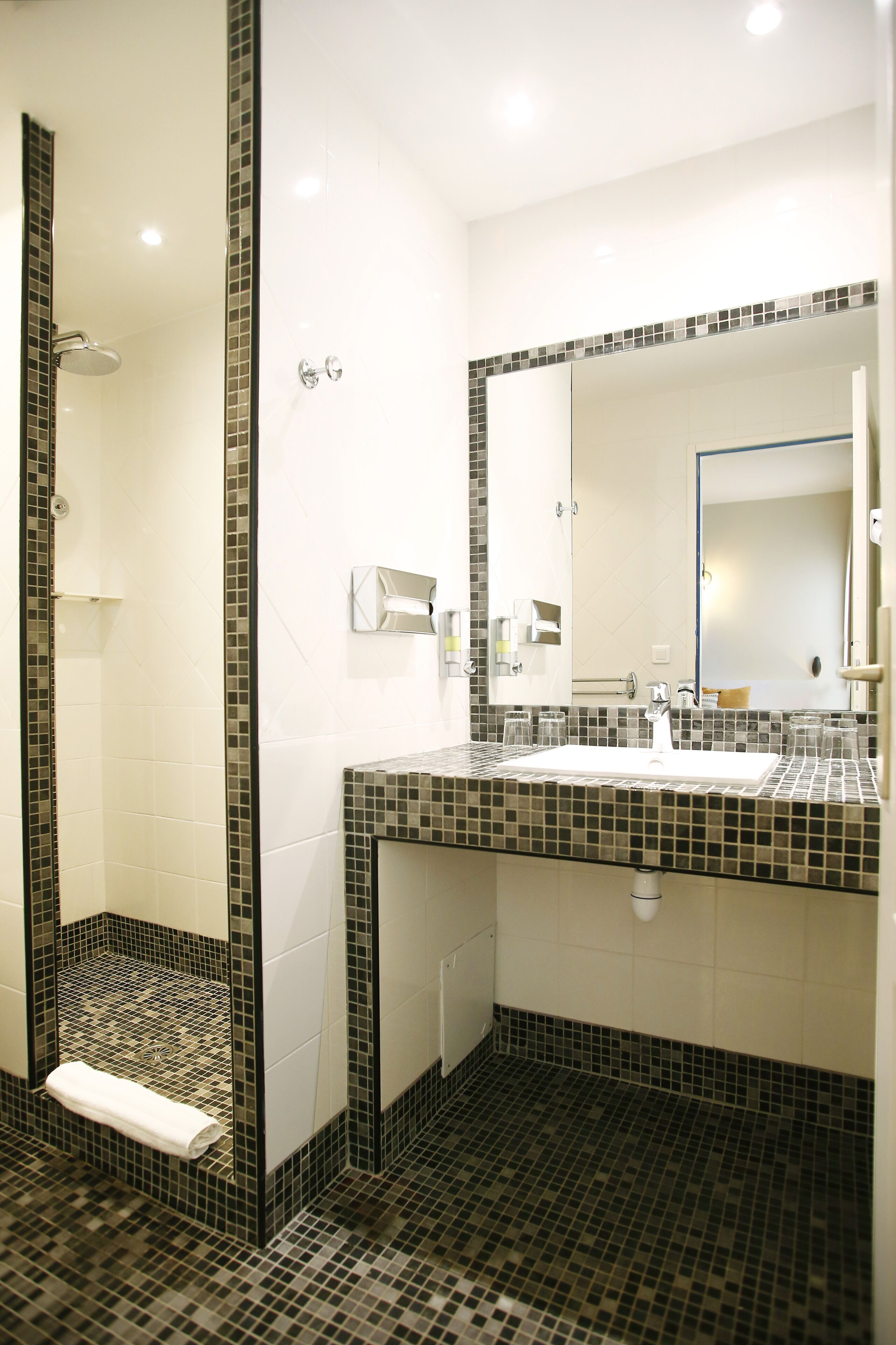 Un baño con ducha, lavabo y espejo.