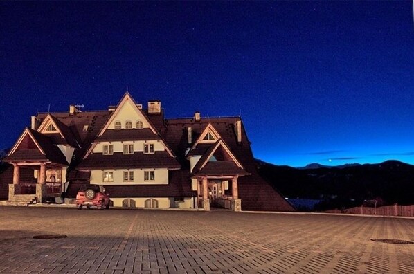 A large, multi-story building with a symmetrical facade, featuring a central tower and multiple wings. - VisitZakopane Vanilla Apartments (Koscielisko)