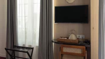 Une chambre d’hôtel comprenant un lit, un bureau avec un téléviseur à écran plat, une lampe et une chaise.