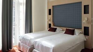 A hotel room with two beds, a large window, and a view of the city. - Marnie House Hôtel (Le Touquet-Paris-Plage)