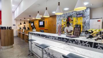 A bar area with a counter, bar stools, and a bartender.