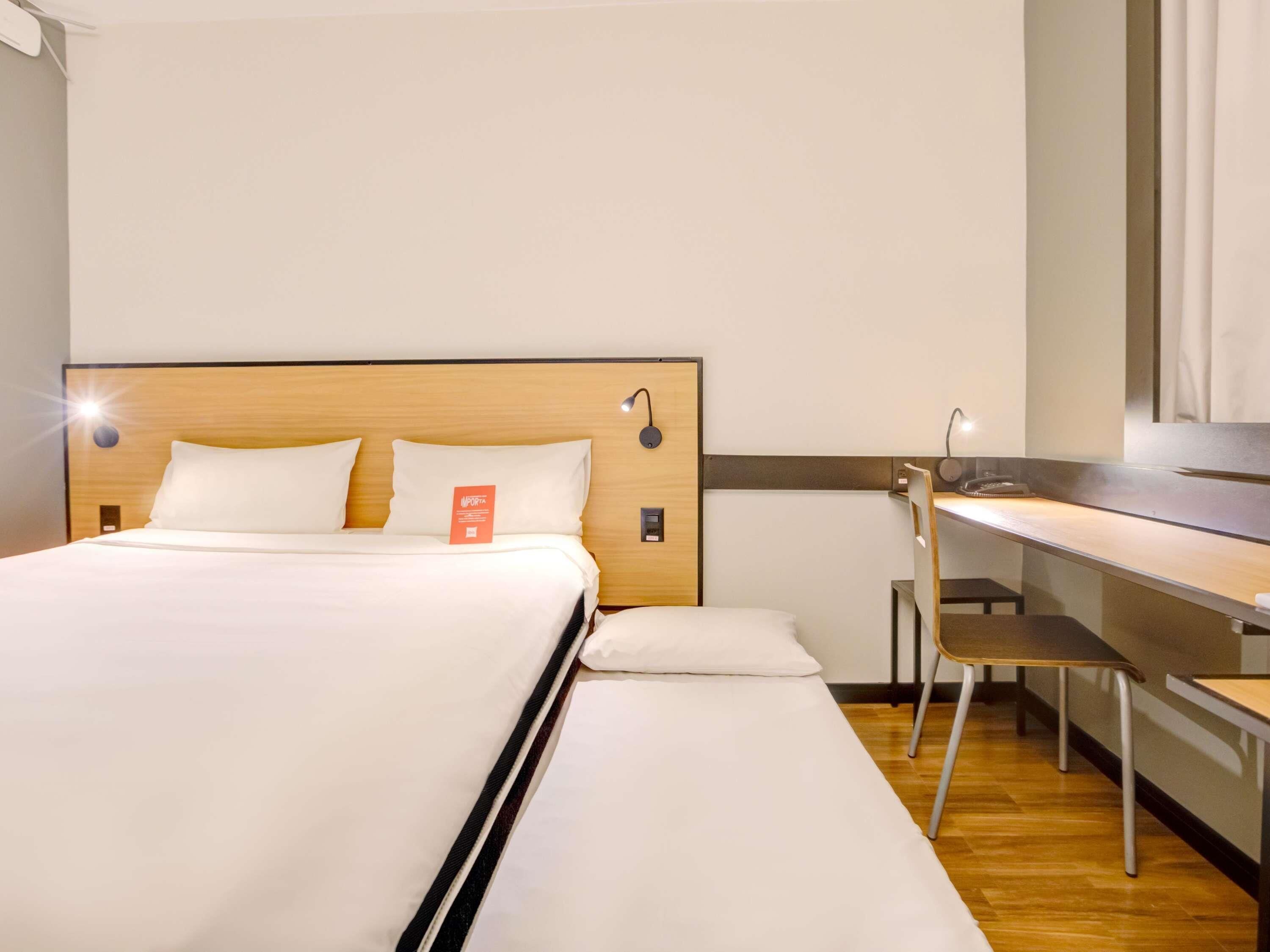 Kamer, meerdere bedden | Een minibar, een bureau, een laptopwerkplek, geluiddichte muren