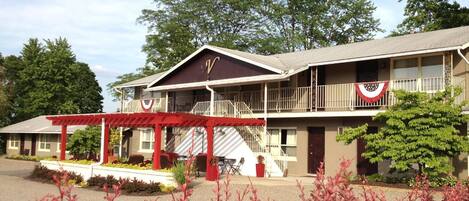 Un motel de dos pisos con toldo rojo y balcón.