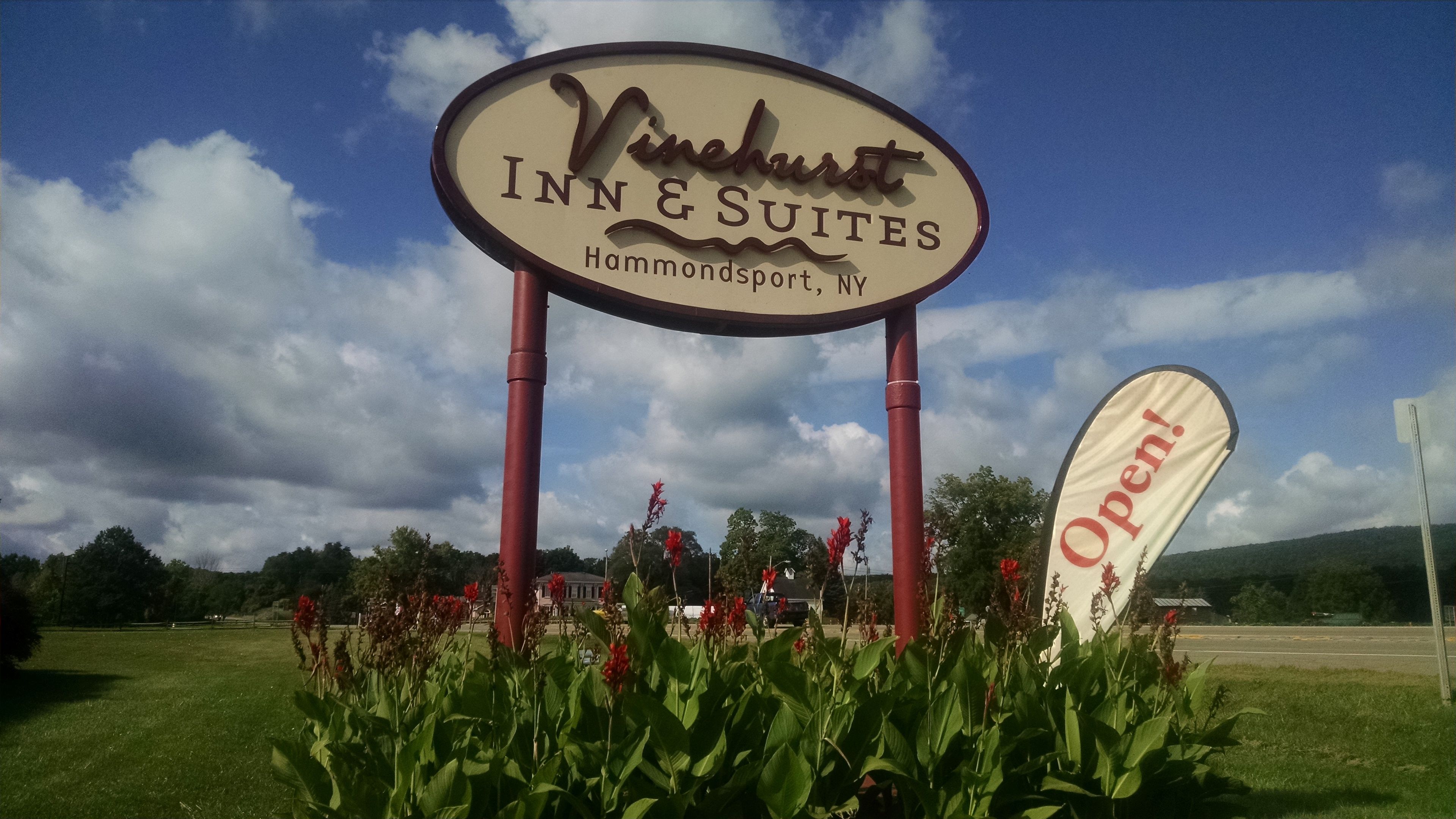 Skilt for Vinchurst Inn & Suites i Hammondport, New York, med klar himmel og grønt i baggrunden.