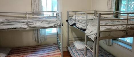 Un dormitorio con literas, una ventana y un ventilador de techo.