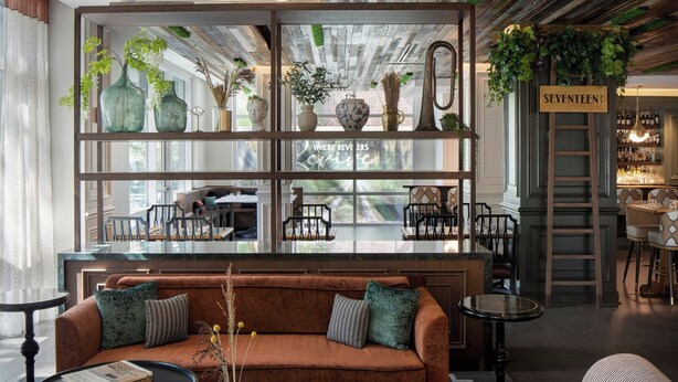 Een modern interieur met een bank, tafels en een bar.