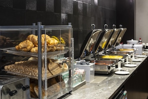 A buffet with various food items, including pastries and hot dishes, displayed in clear containers. - Residence Inn Boston Logan Airport/Chelsea (Chelsea)