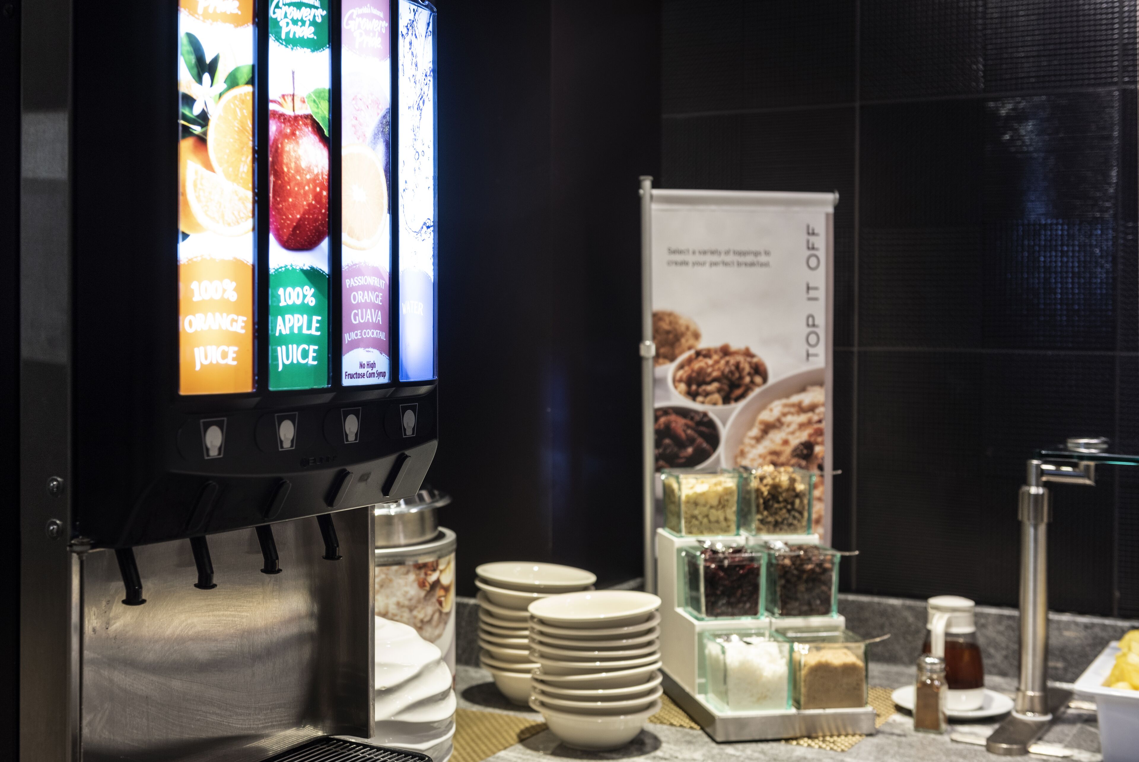 A juice dispenser with options for orange, apple, and guava juice, and a display of various breakfast items.