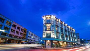 A multi-story hotel with a prominent sign reading "GREEN HOUSE HOTEL" and a modern architectural design.