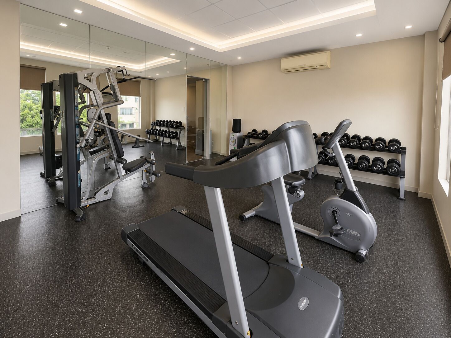 A gym with treadmills, dumbbells, and weight machines.