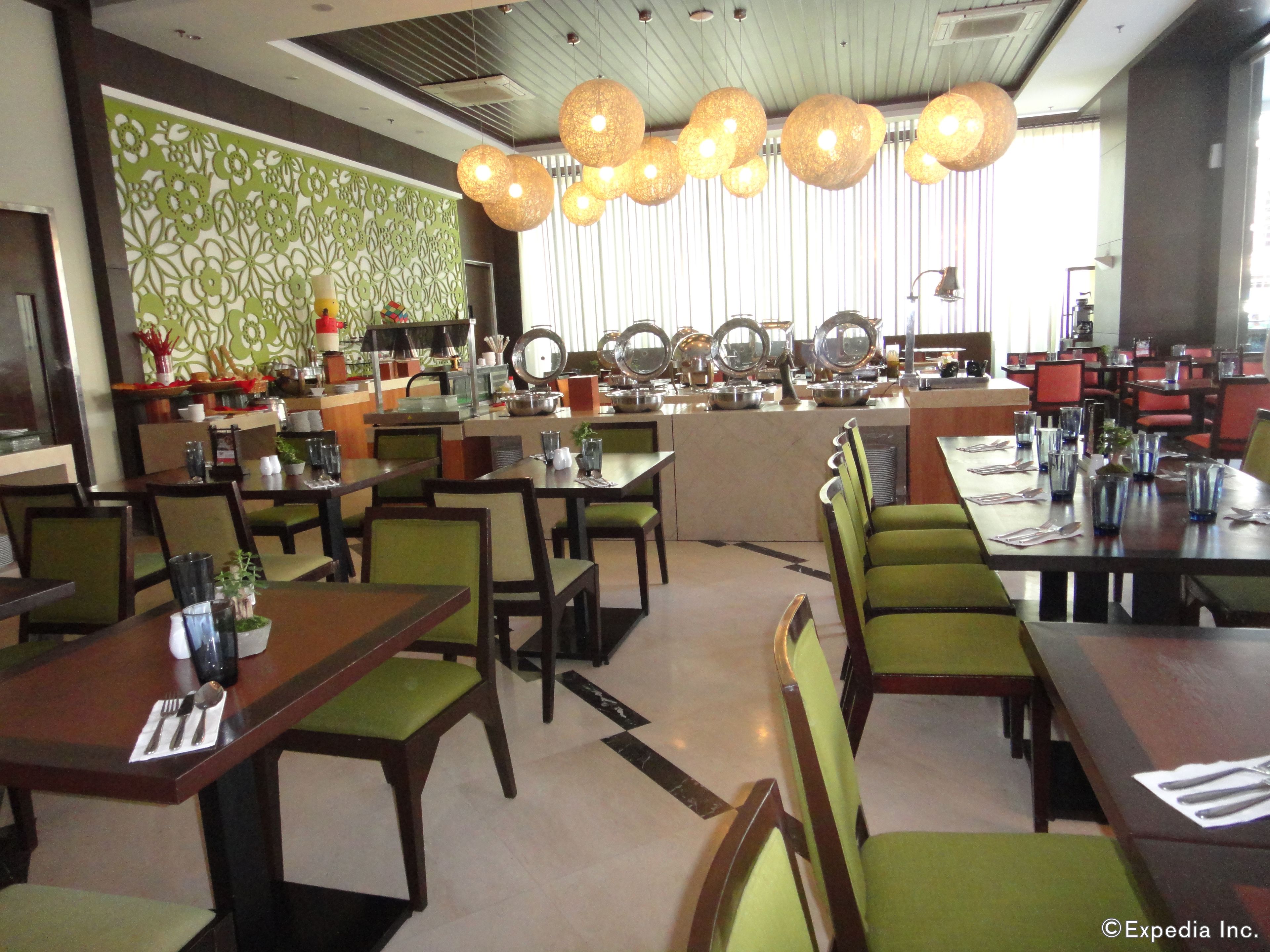 A restaurant with multiple dining tables and chairs, a counter with various kitchen items, and hanging pendant lights.