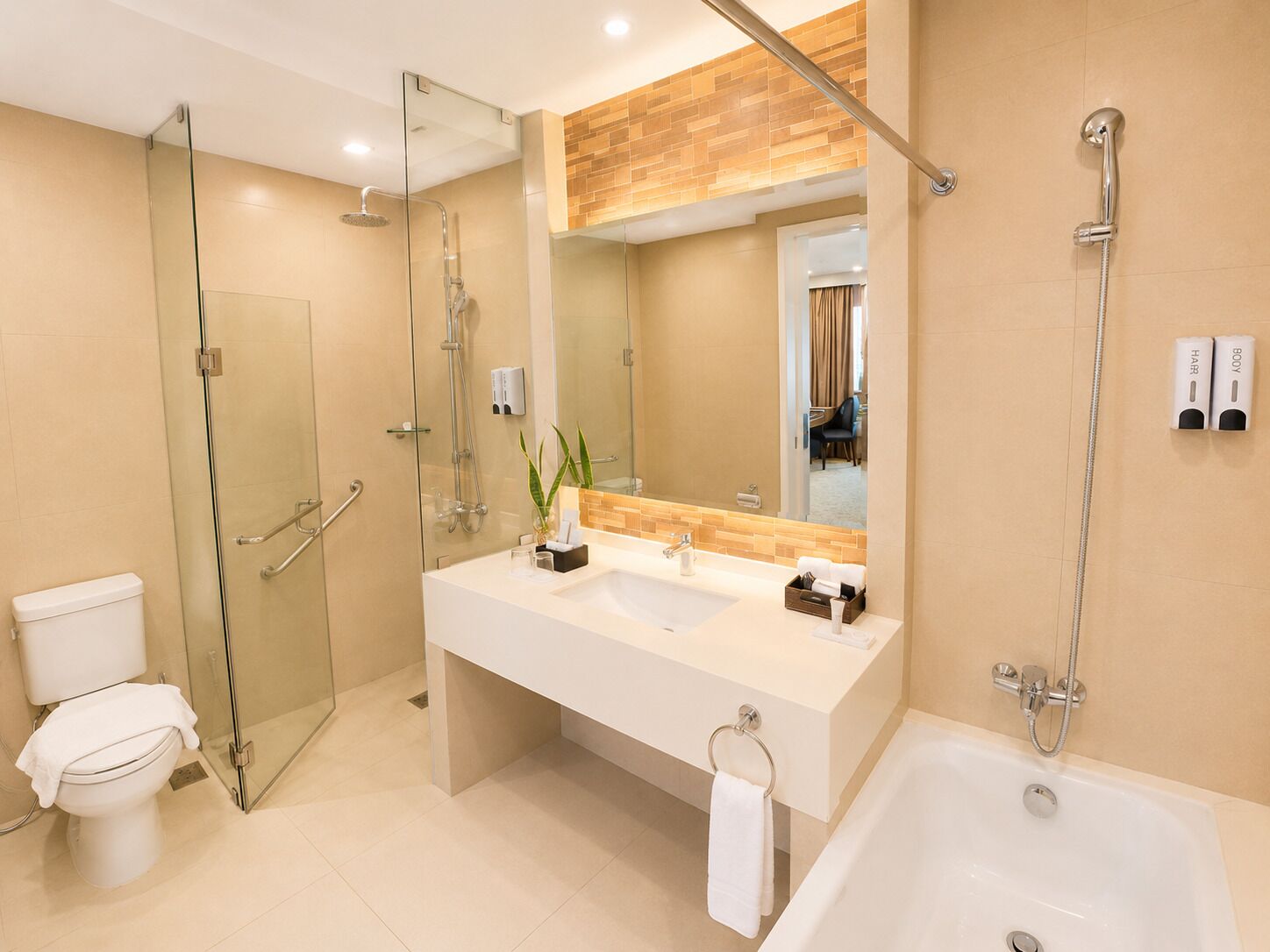 A modern bathroom with a glass shower enclosure, a bathtub, a double sink vanity, and a toilet.