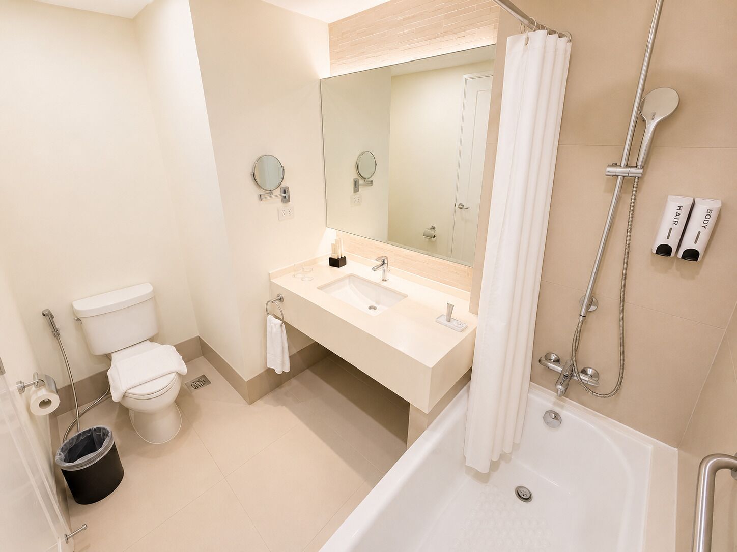 Un baño moderno con bañera, ducha, inodoro y lavabo.