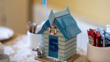 A small wooden house model with a flag, numbered 5, and a life ring on the roof.