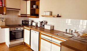 A modern kitchen with a stove, oven, dishwasher, and a sink. - Inn at Port nan Gael (Isle of Mull)