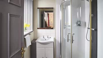 A bathroom with a shower, sink, and mirror.