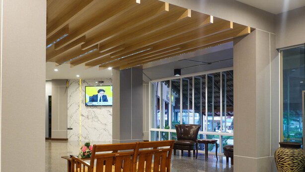 A lobby with a wooden bench, a TV screen, and a large window. - Krabi Royal Hotel (Krabi)