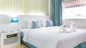 A hotel room with a bed, a nightstand with a lamp, a phone, and a window with curtains. - Krabi Royal Hotel (Krabi)
