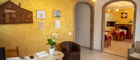 A reception area with a wooden desk, framed certificates, and a potted plant.