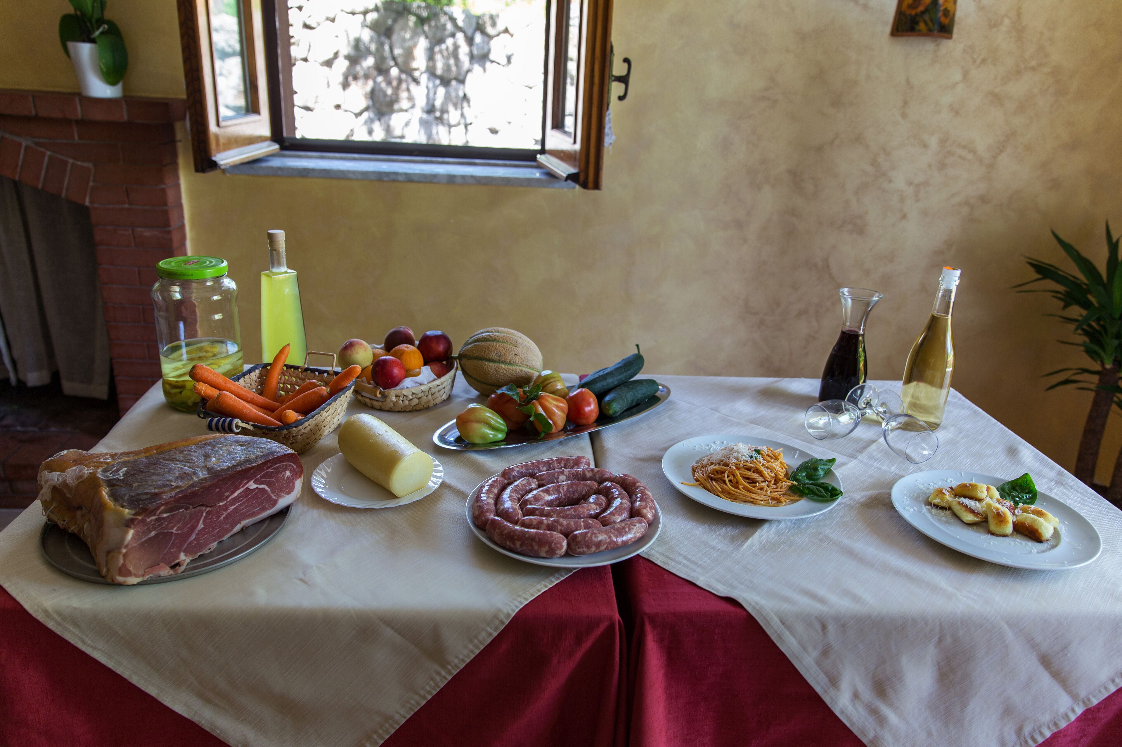 Una mesa con diversos alimentos, como carne, verduras y platos de pasta.