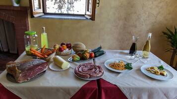 Una mesa con diversos alimentos, como carne, verduras y platos de pasta.