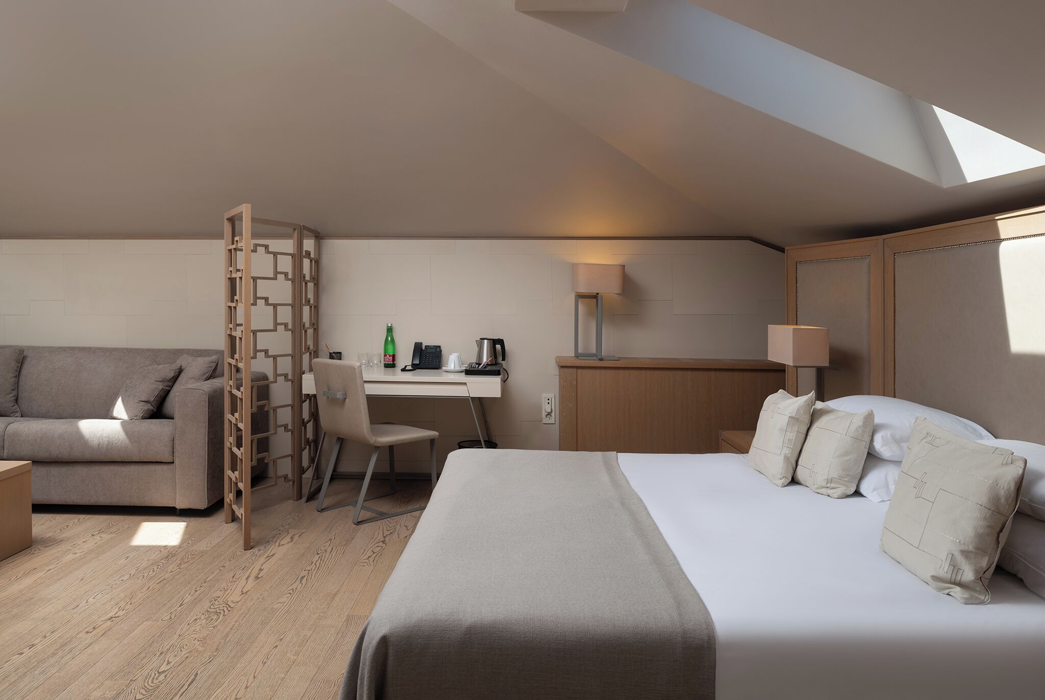 Une chambre d’hôtel moderne équipée d’un lit, d’un bureau, d’une chaise et d’un canapé.