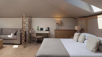 Une chambre d’hôtel moderne équipée d’un lit, d’un bureau, d’une chaise et d’un canapé.