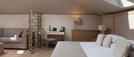 Una habitación de hotel moderna con una cama, un escritorio, una silla y un sofá.