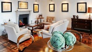 A living room with a fireplace, a sofa, a coffee table, and a dining table with a centerpiece.