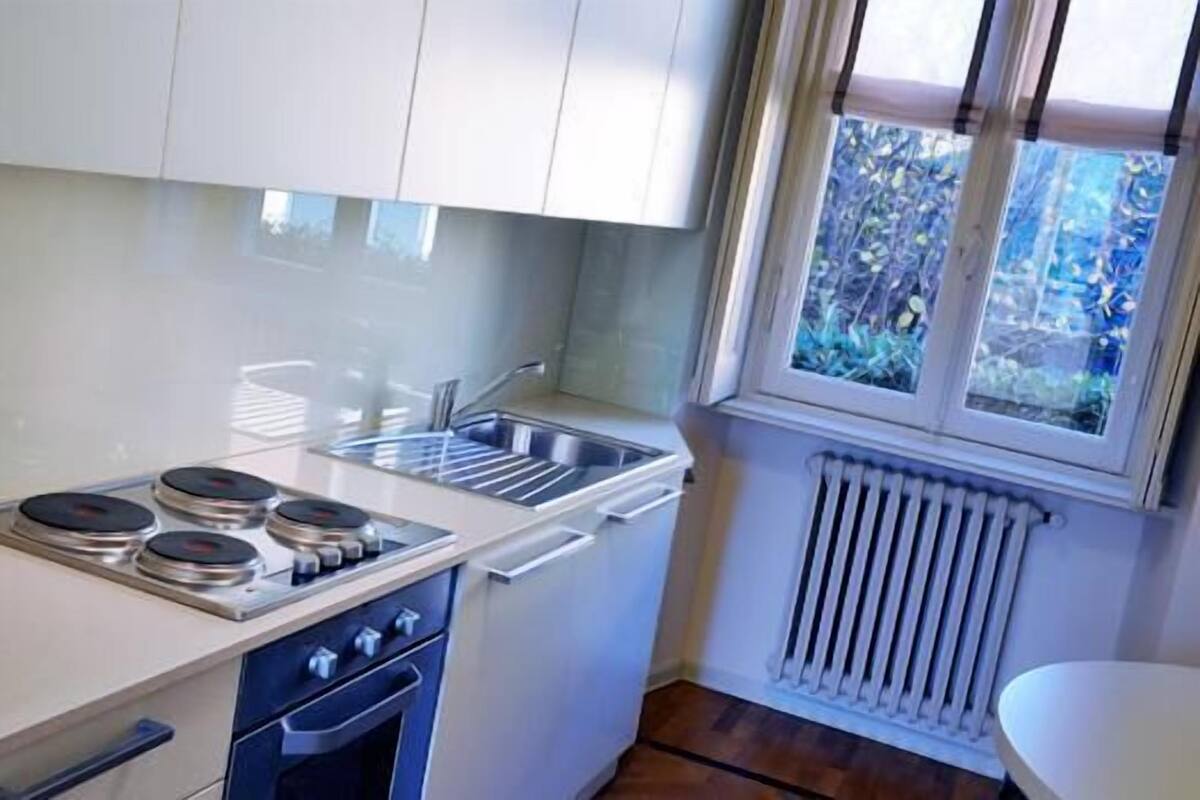 A compact kitchen with a gas stove, oven, and a built-in sink.