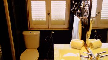 A bathroom with a toilet, sink, and mirror.