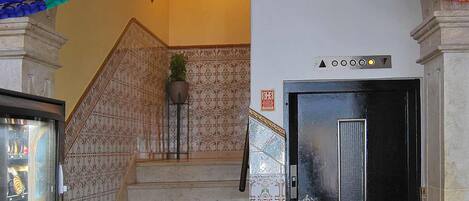 Un escalier avec une porte d’ascenseur noire et une arche décorative.