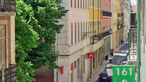 A street view with buildings, a tree, and a green sign with 'Norte Guesthouse 161'.