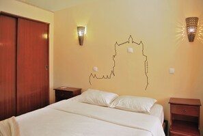 A hotel room with a bed, wooden wardrobe, two nightstands, and wall-mounted lights. - 161 Norte Guesthouse (Lisbon)