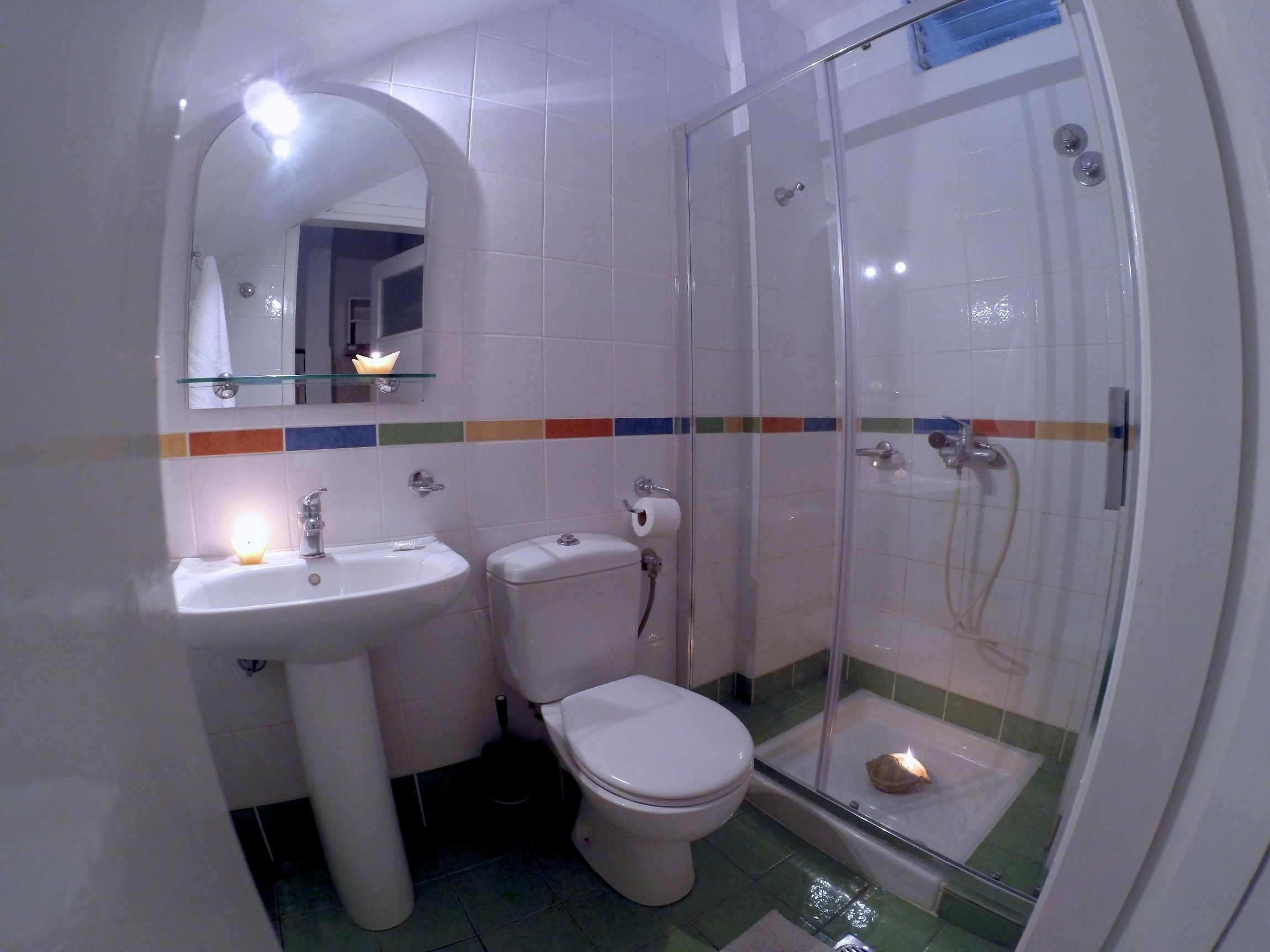 Un baño con ducha de vidrio, lavamanos e inodoro.