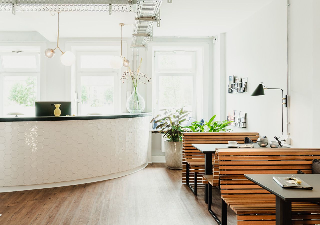 Een moderne keuken met een gebogen kookeiland, houten banken en hanglampen.