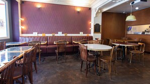 A restaurant interior with booths, tables, and chairs. - Hôtel Marignan (Paris)